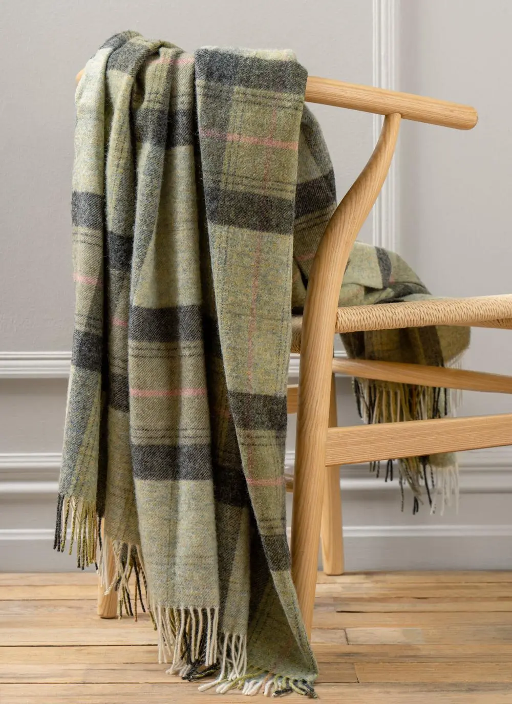Green plaid wool throw draped across wooden chair